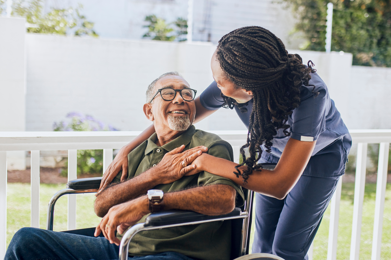 nurse talking to elderly man in wheelchair